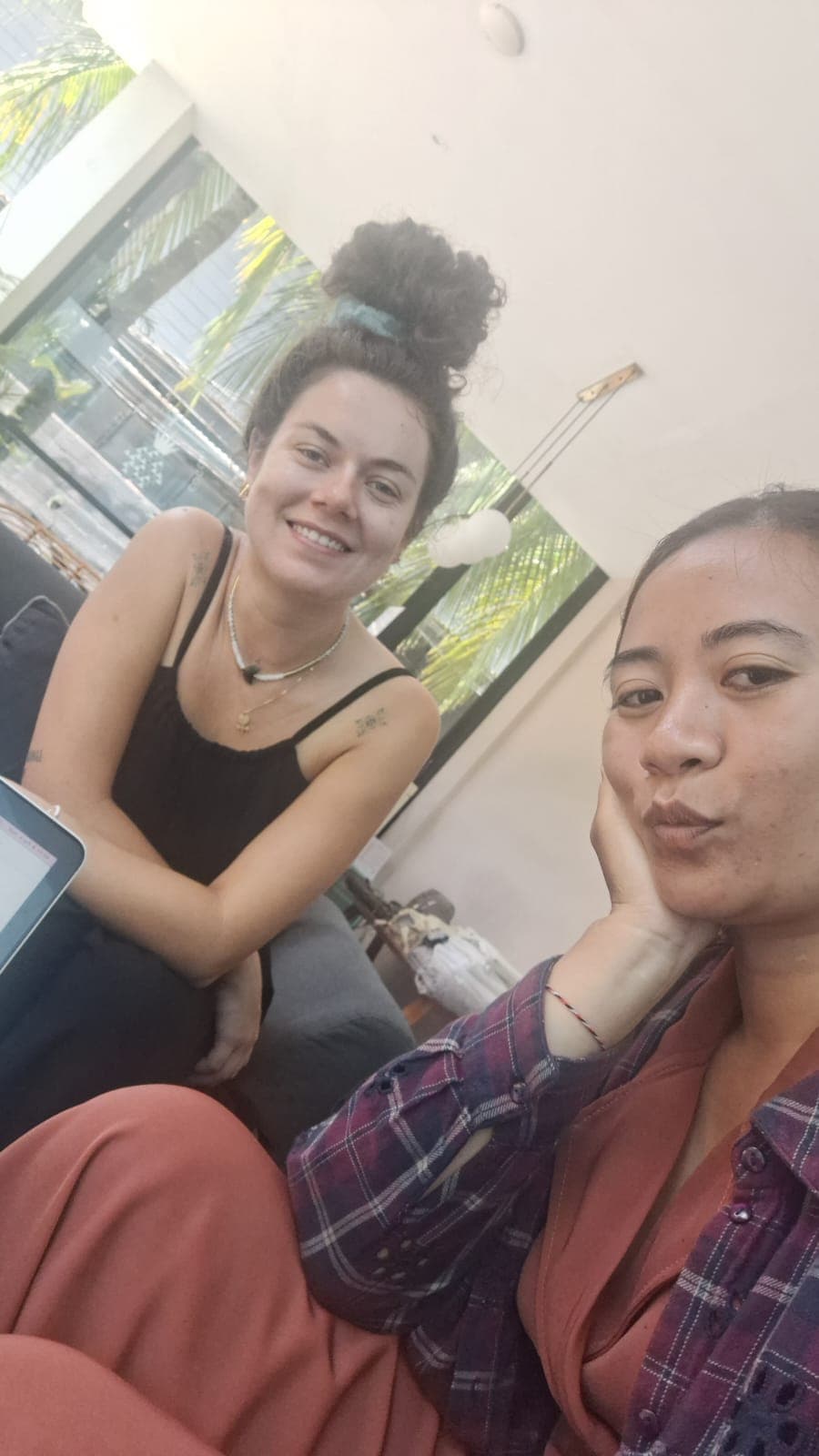 Deux femmes posent pour un selfie, l'une sourit et l'autre fait une moue expressive.